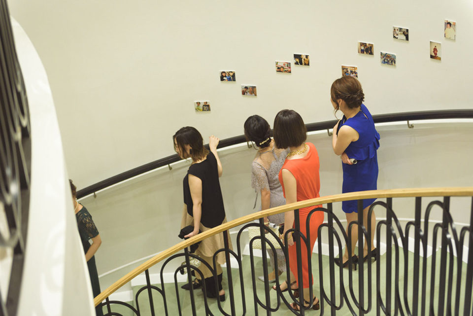 螺旋階段に飾られた写真を見る女性ゲスト